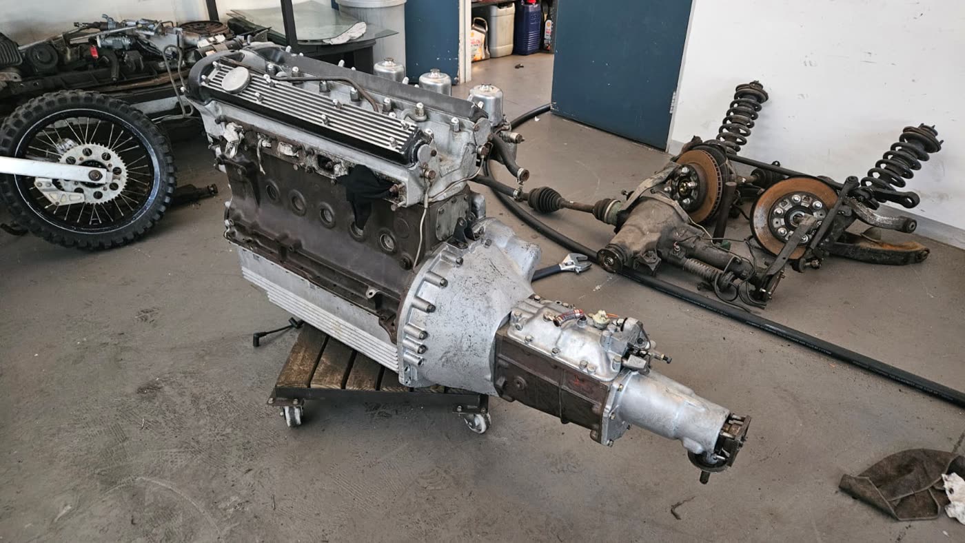 Classic Jaguar straight-six engine and gearbox on a stand after dry ice cleaning